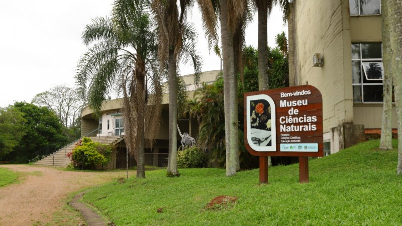 Imagem externa da sala de exposições do museu de ciências naturais e placa de bem-vindos!