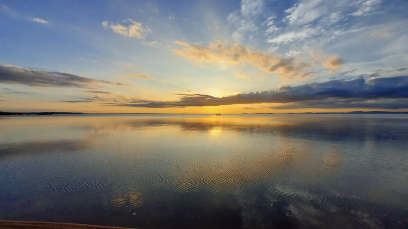 por do sol na lagoa, em tons de amarelo e azul