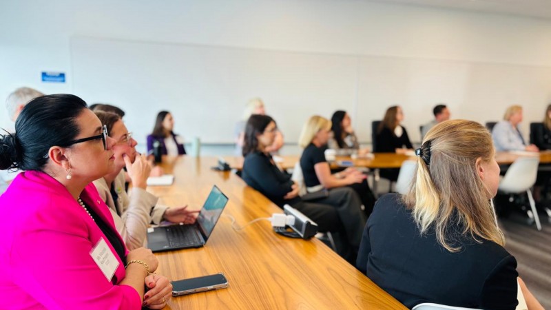 secretaria marjorie esta vestida com um blazer rosa. ela olha de lado para uma pessoa que fala.